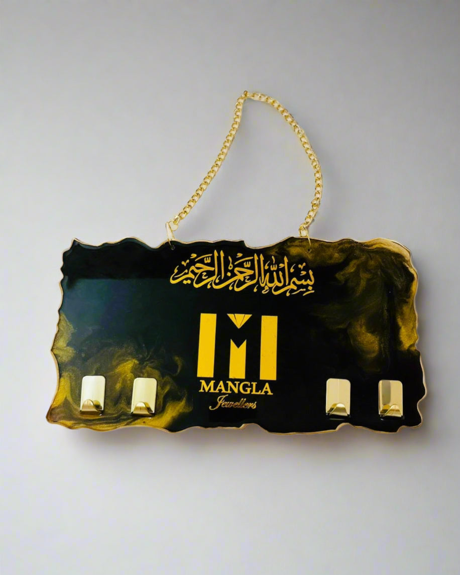 Decorative handmade keyholder hanging sign with gold text and business branding logo on a white background