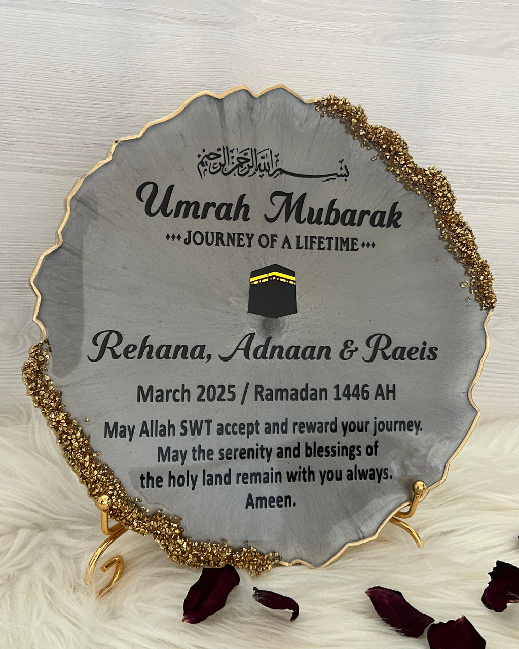 Round gray plaque with gold edge and 'Umrah Mubarak' text on a white background