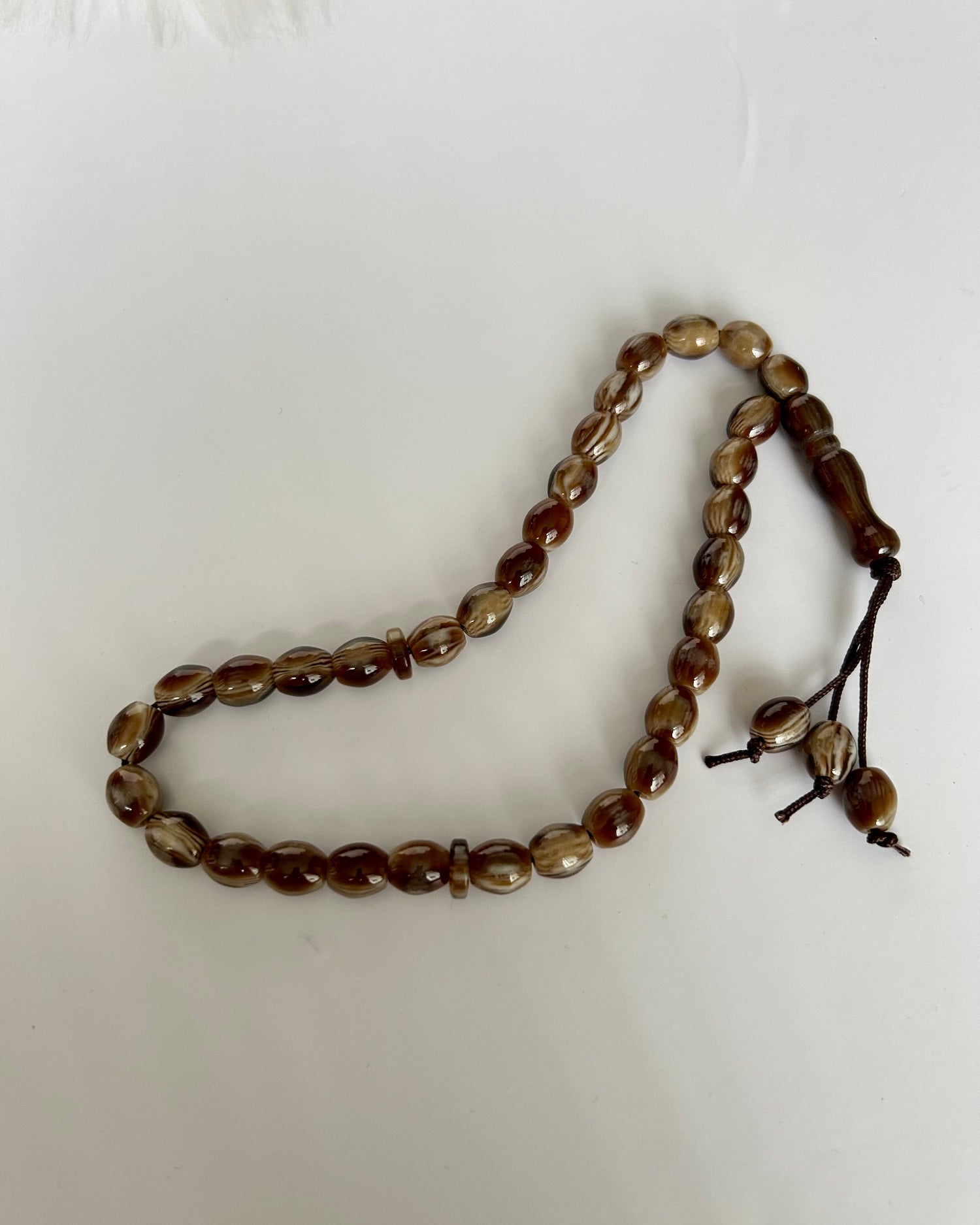Brown beaded prayer beads on a white background