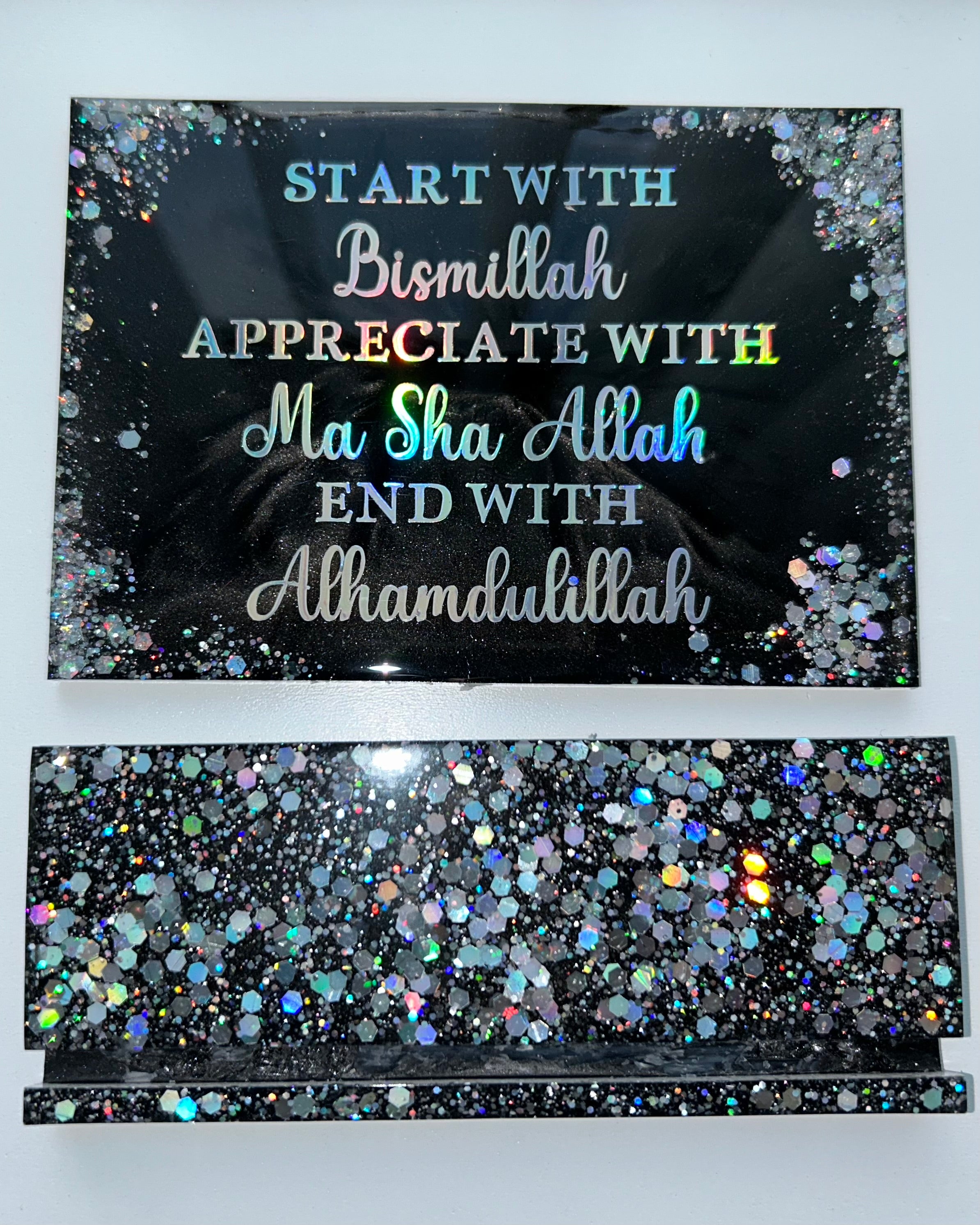 Decorative sign with Arabic text on a glittery black background
