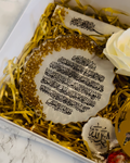 Decorative plate with Arabic text on a bed of gold shreds in a box with bookmark with Arabic text 'Bislmillah' and a keyring with Arabic Text  