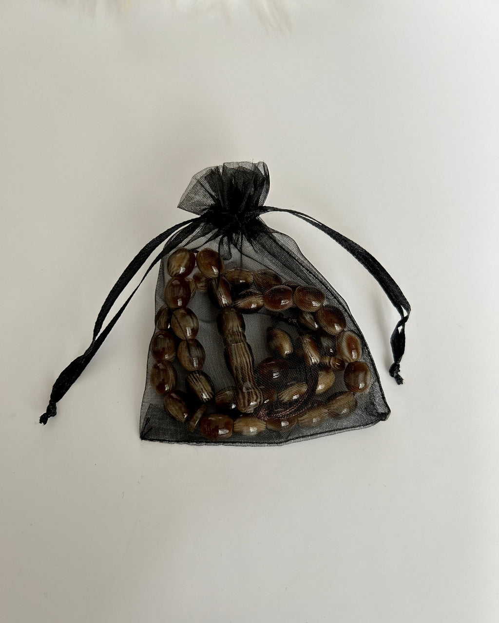 Black drawstring bag with wooden beads on a white background