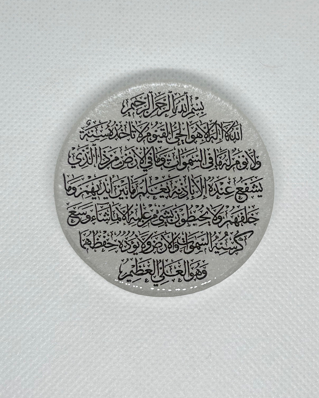 Circular metallic object with engraved text on a white background