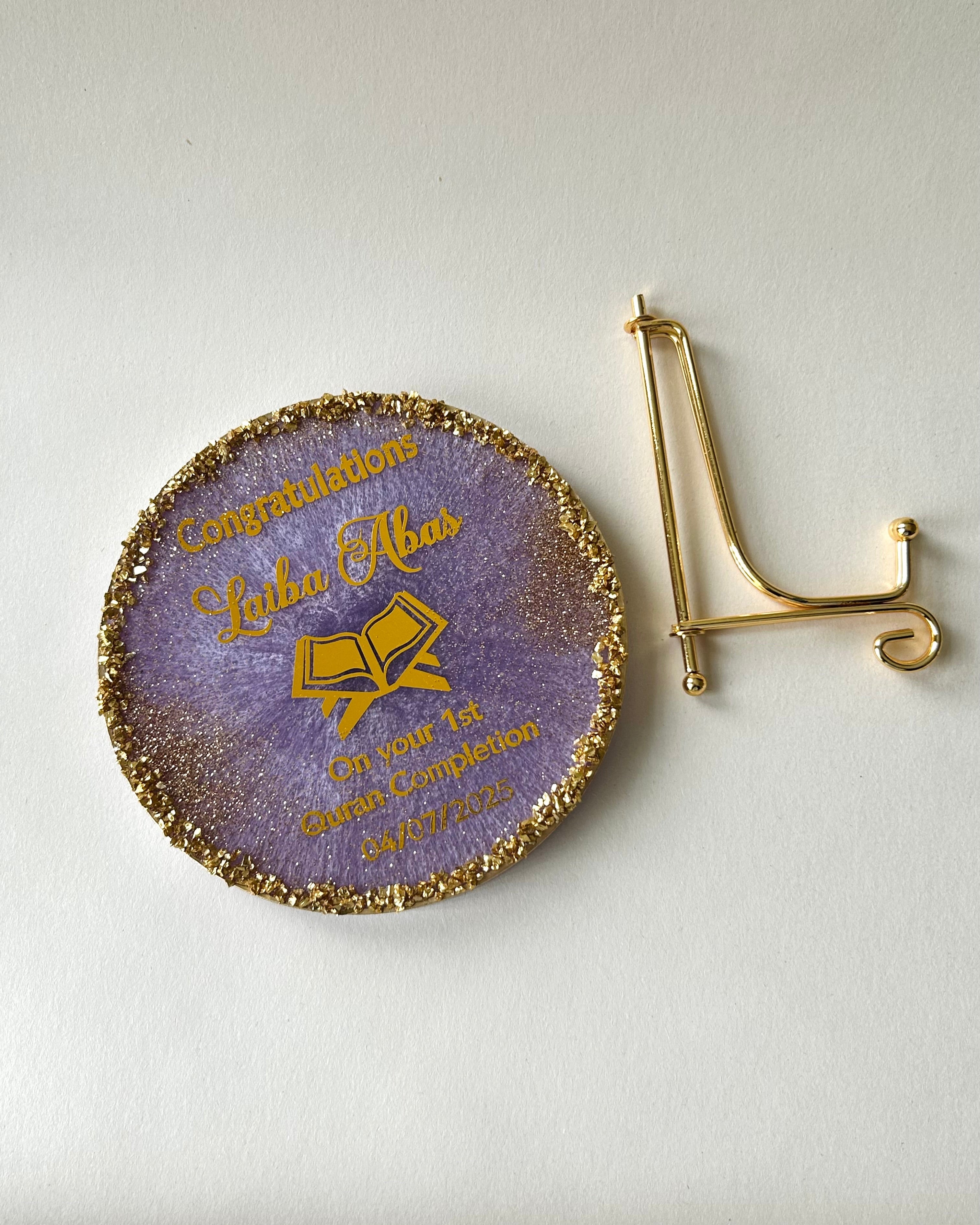 Decorative coaster with gold text and a letter 'A' on a white background