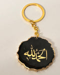 Keychain with gold Arabic text on a black background