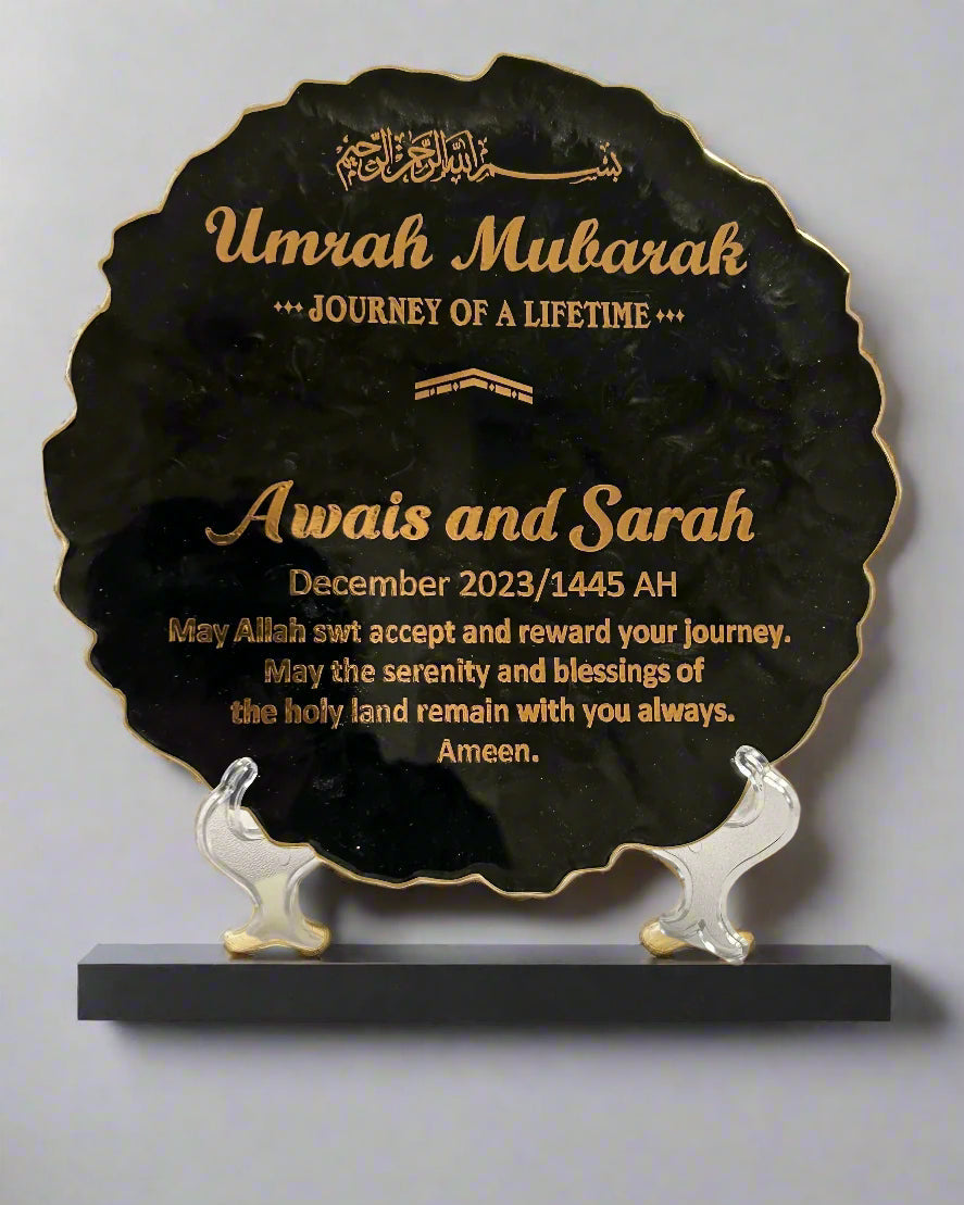 A custom plaque with gold crushed glass edges and a gold cast iron stand, featuring black background and gold text for a personalized message.