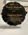A custom plaque with gold crushed glass edges and a gold cast iron stand, featuring black background and gold text for a personalized message.