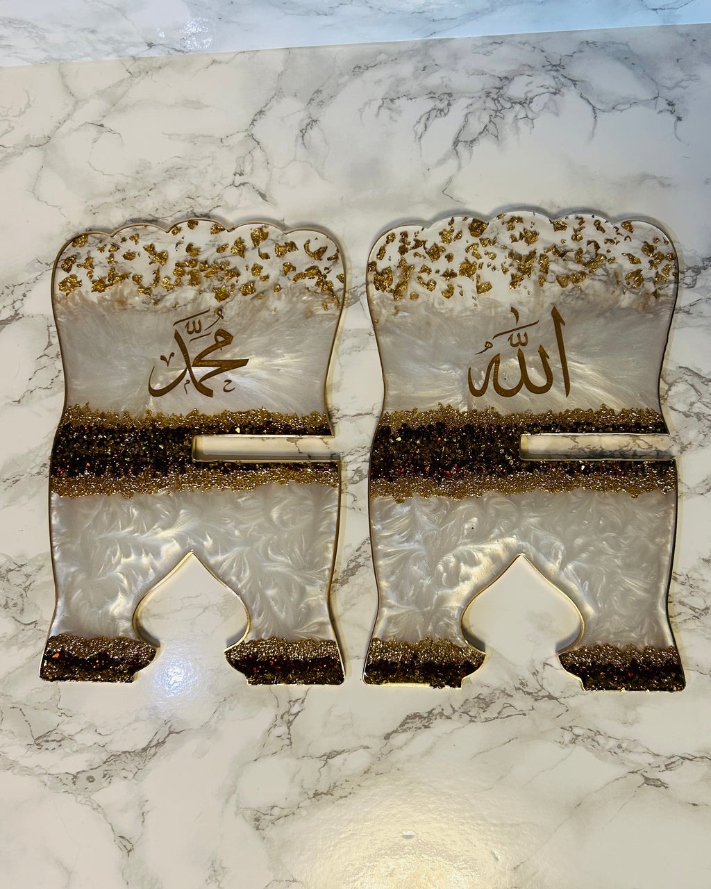 Decorative metal hinges with engraved text on a marble surface