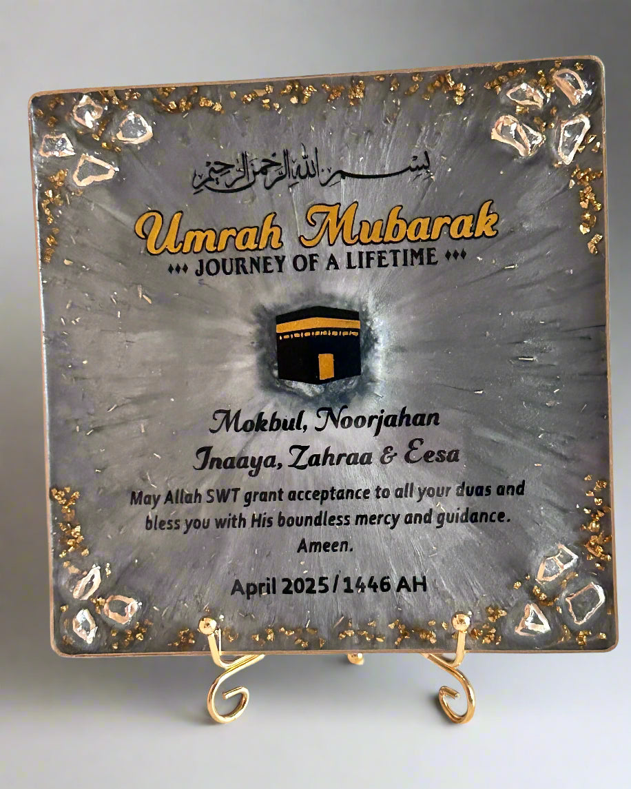 Decorative plaque with 'Umrah Mubarak' text and image of the kaaba design on a marble surface