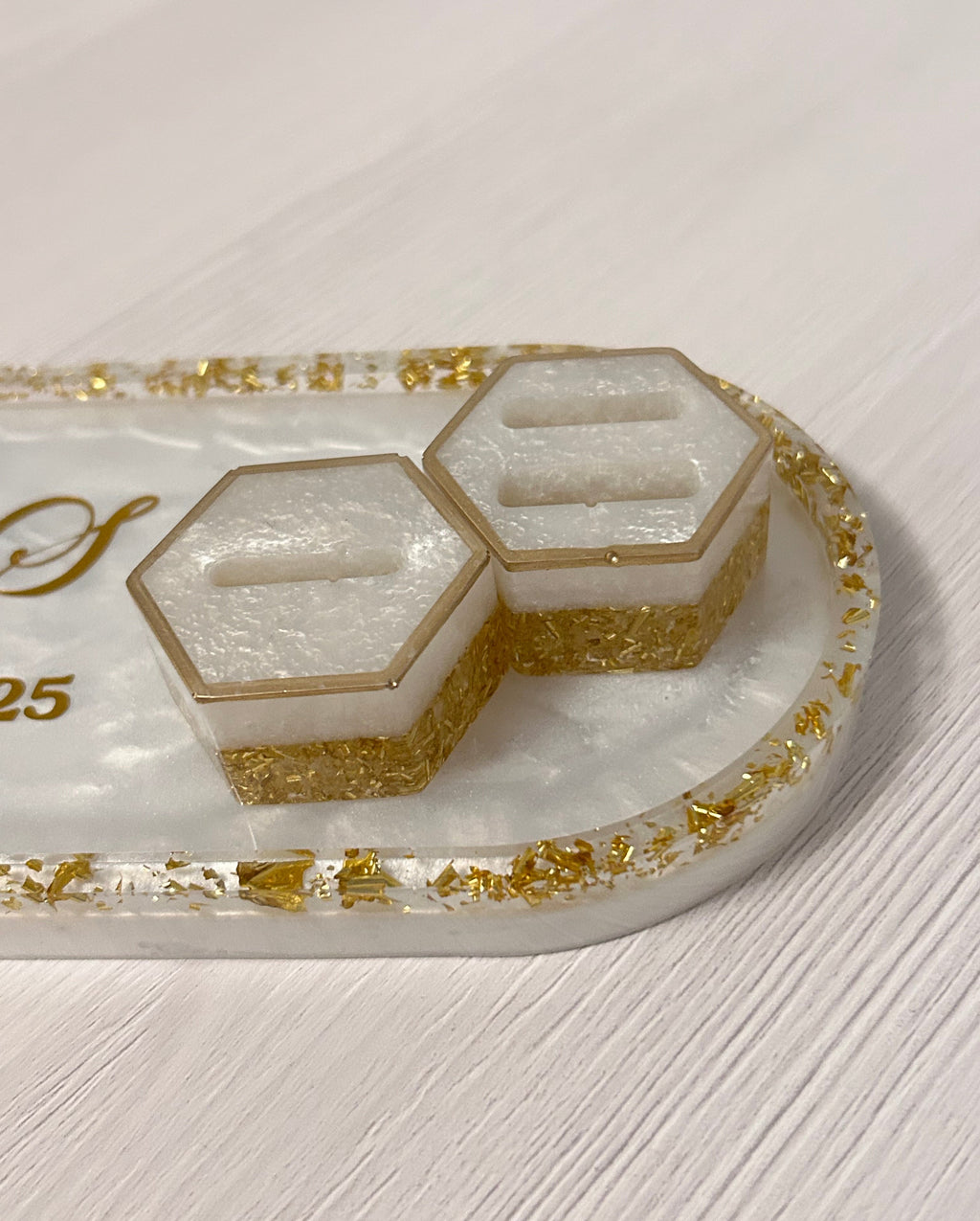 Decorative trinket tray with 2 hexagon ring holders in gold accents on a white background