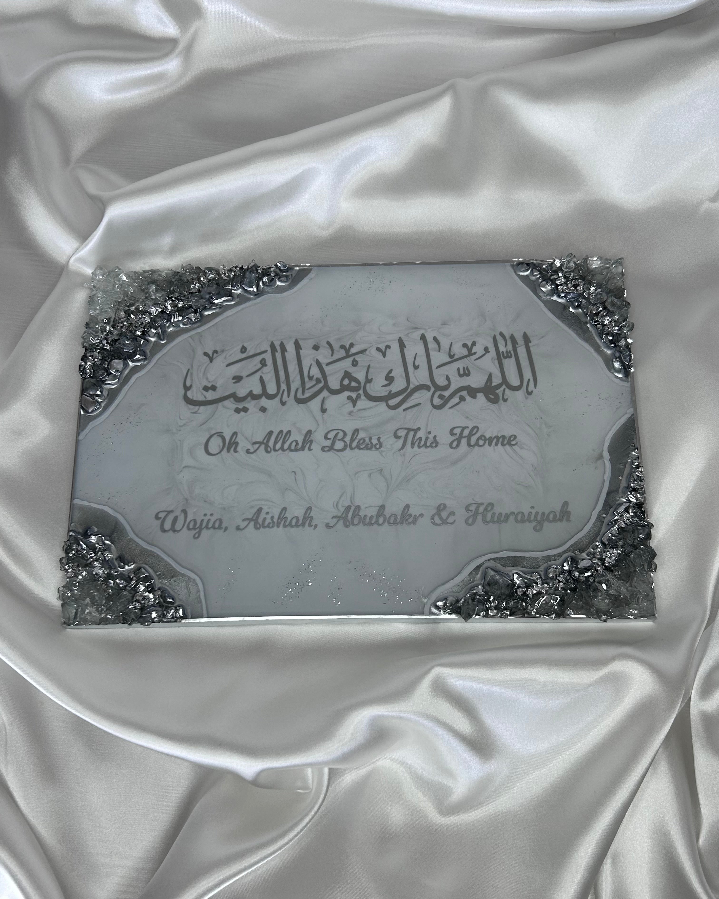 Decorative plaque with Arabic text and 'Oh Allah Bless This Home' on a white satin background