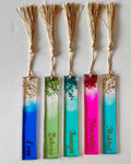 Set of colorful bookmarks with names in gold vinyl with gold tassels on a white background