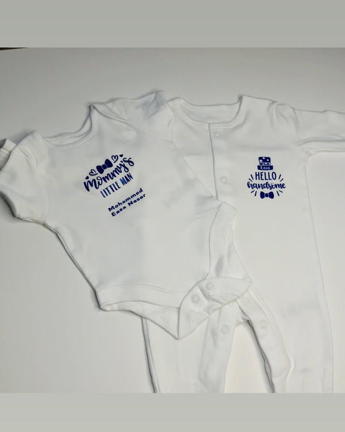 Two white baby onesies with blue text on a light gray background
