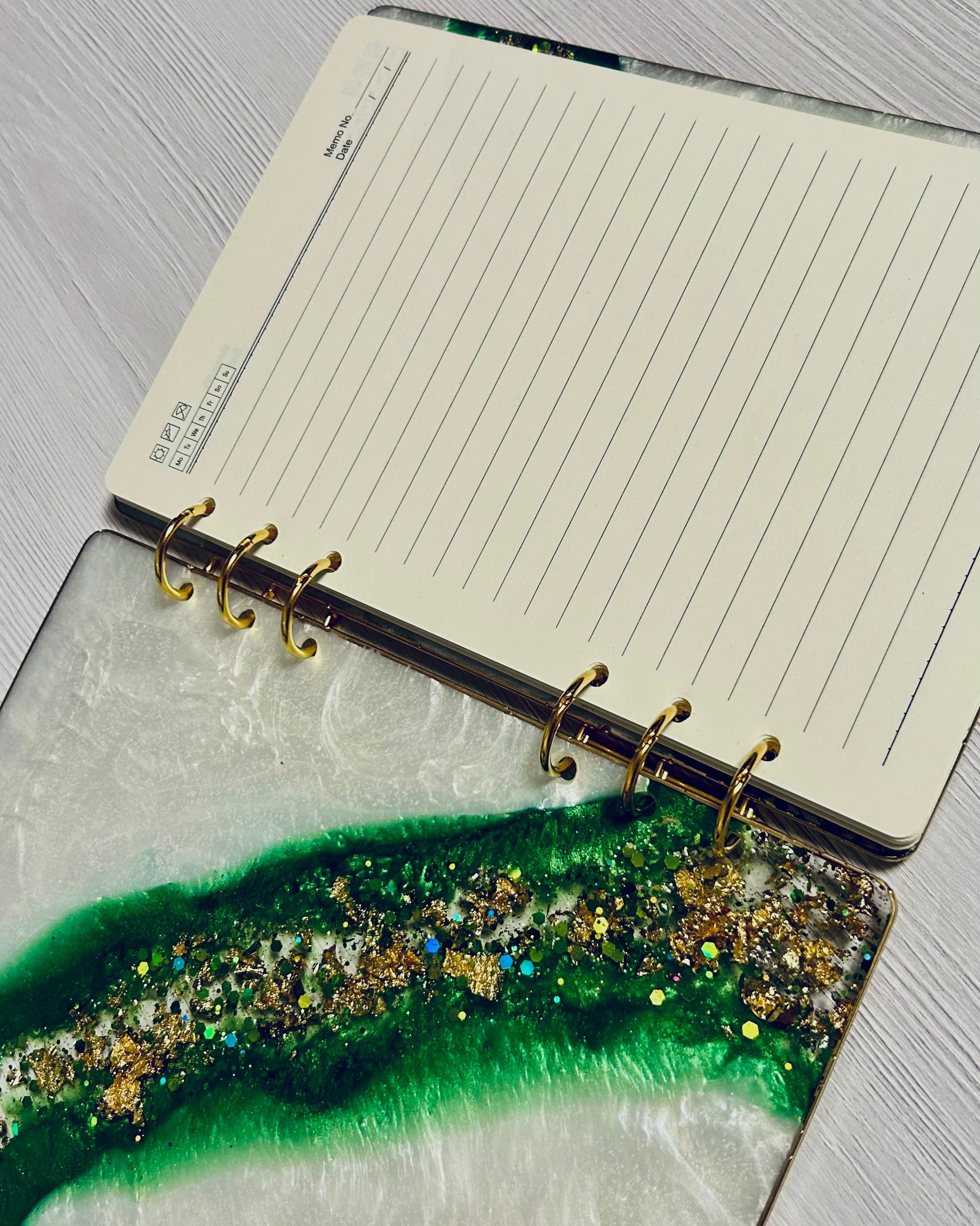Notebook with a green and gold resin cover on a gray surface
