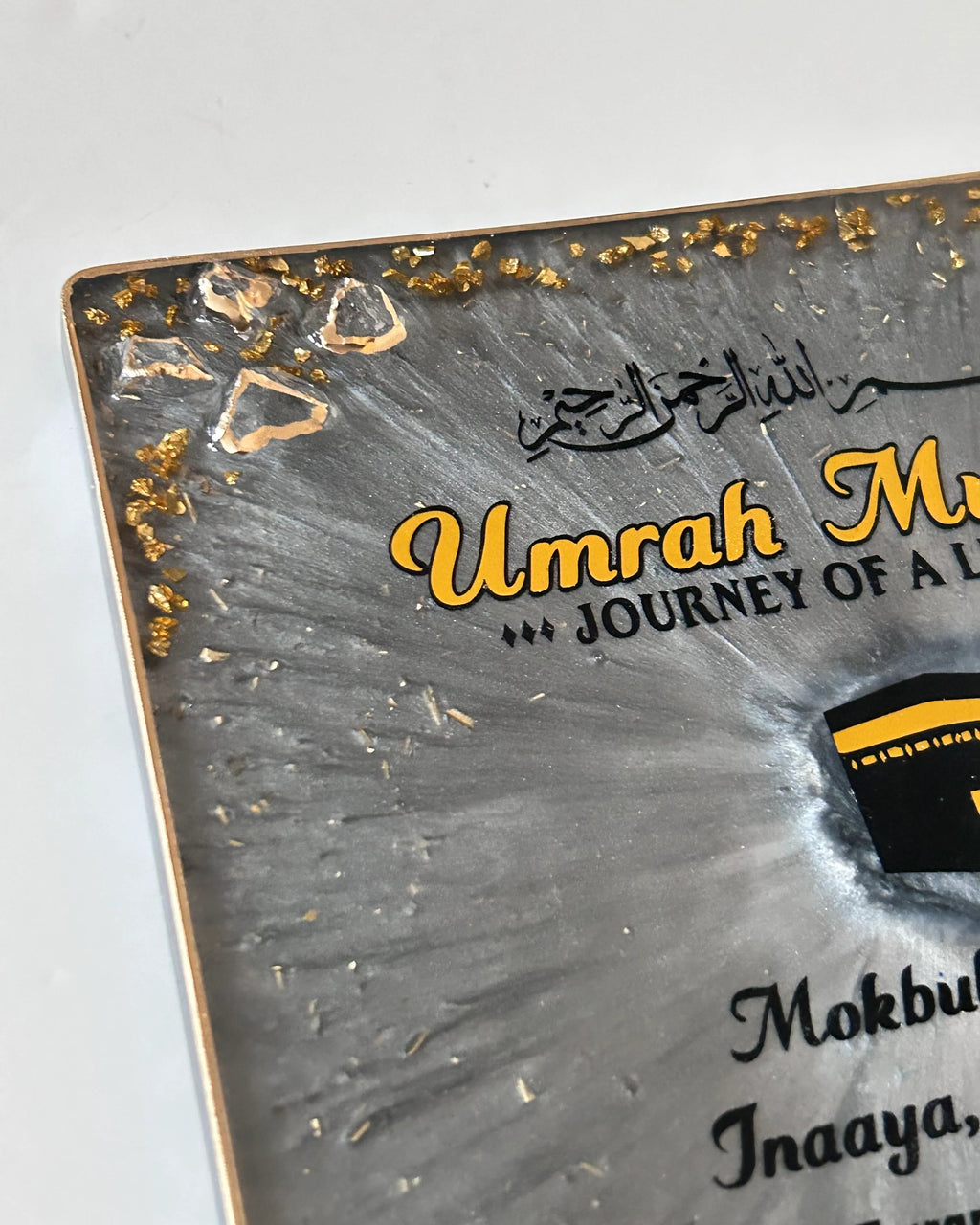 Metallic resin plaque with 'Umrah Mubarak' branding on a grey background